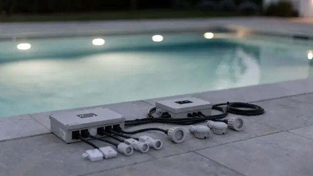 Poolbeleuchtung mit LED-Unterwasserlampen, Steuerbox und Zubehör am Beckenrand