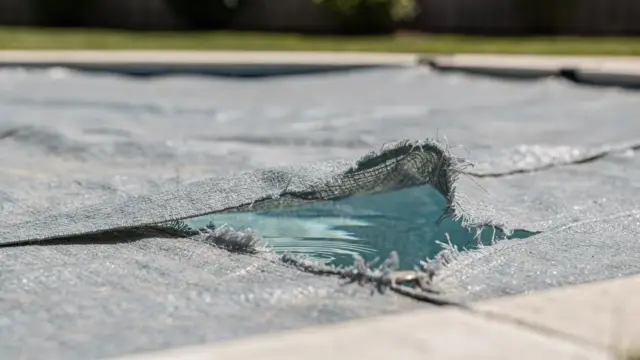 Gerissene Poolabdeckung am Pool: Beschädigung und Reparaturbedarf für den Artikel