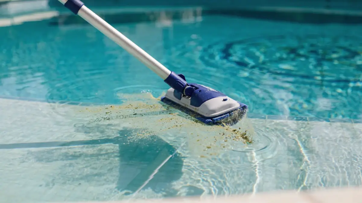 Poolboden reinigen mit Poolkescher und Sauger zur Entfernung von Schmutz und Algen