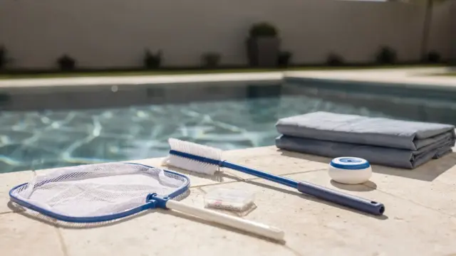 Poolausstattung mit Skimmer, Bürste, Thermometer und Teststreifen am privaten Pool