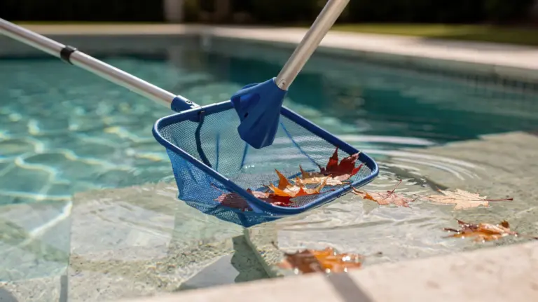 Poolkescher für Laub neben einem Schwimmbecken mit herabgefallenen Blättern