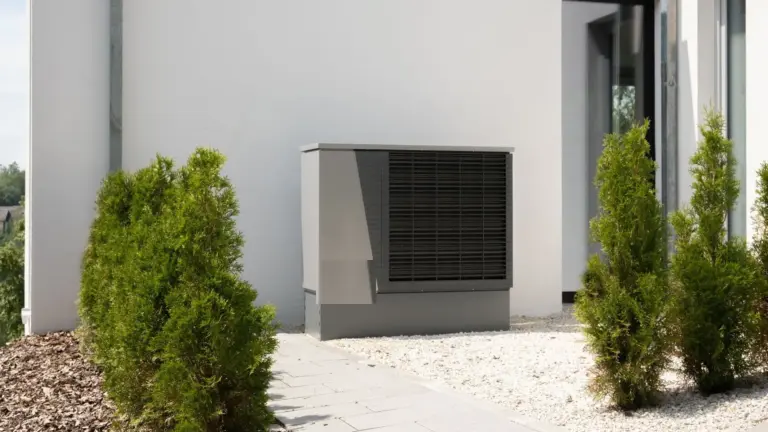 Pool-Wärmepumpe neben einem Haus im Garten